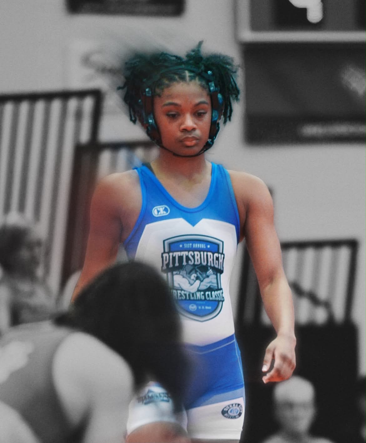 Tamara Humphries walking onto the mat at the Pittsburgh Wrestling Classic in a blue singlet and headgear.